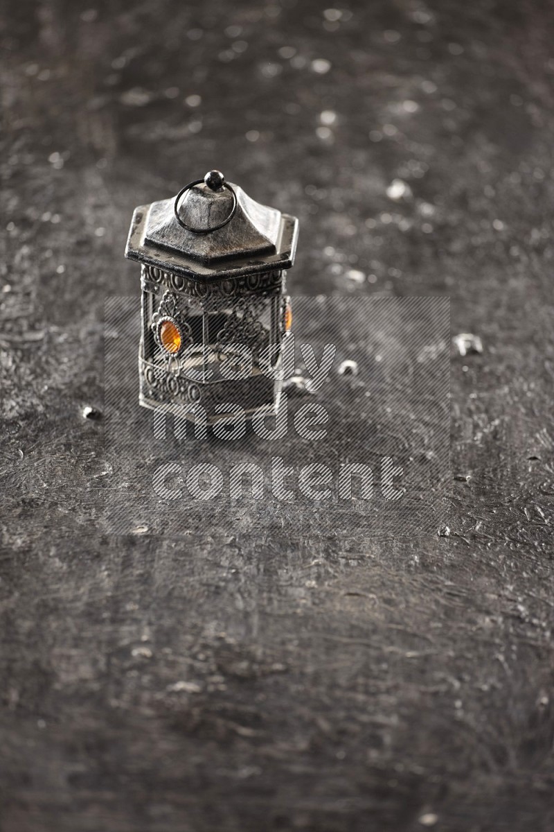A lantern placed on a textured black background