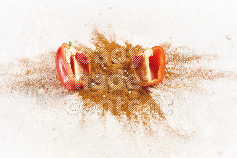 A bunch of ground paprika powder with two halfs of red bell pepper on white background