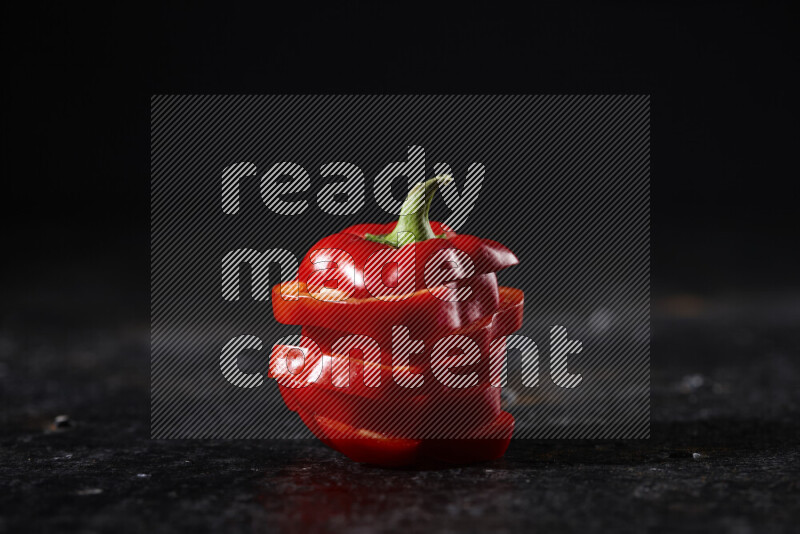 Red bell pepper slices on black background