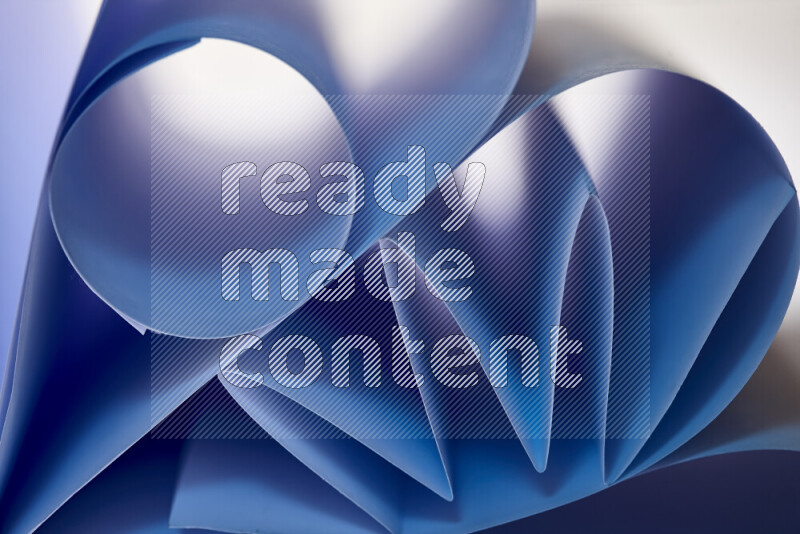 An artistic display of paper folds creating a harmonious blend of geometric shapes, highlighted by soft lighting in blue tones