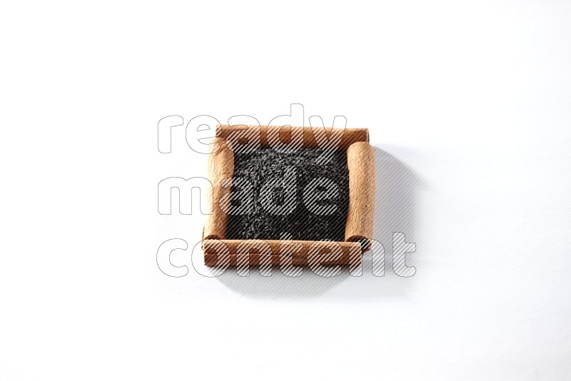 A single square of cinnamon sticks full of black seeds on white flooring