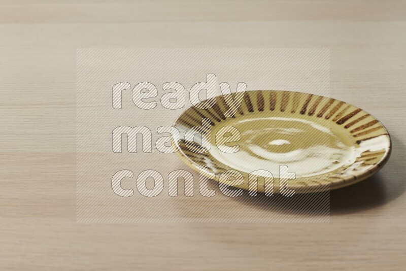 A multicolored pottery plate on light wooden background