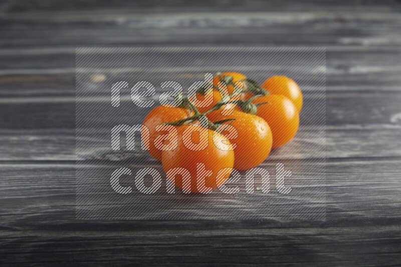 orange cherry tomato vein on a textured grey wooden background 45 degree