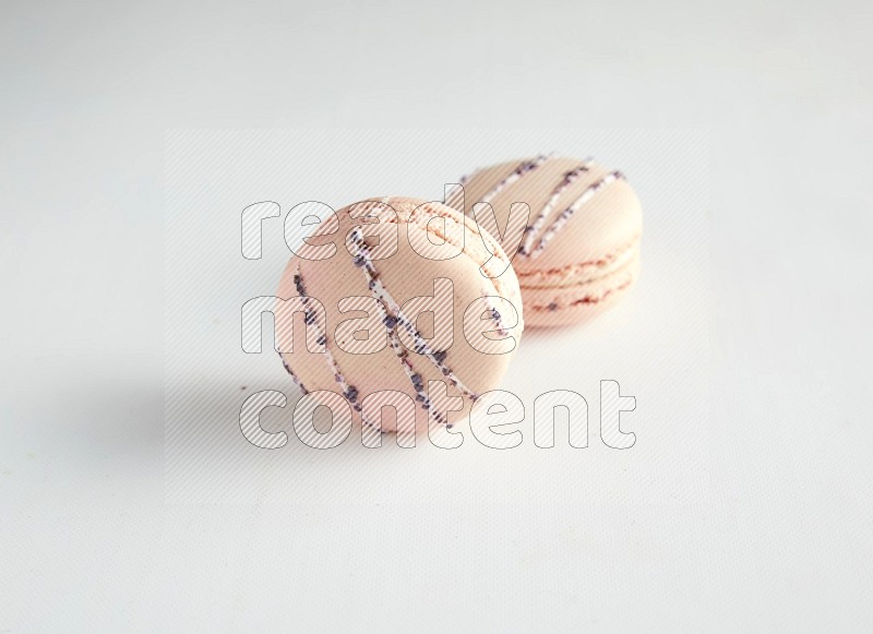 45º Shot of two pink orange blossom macarons on white background
