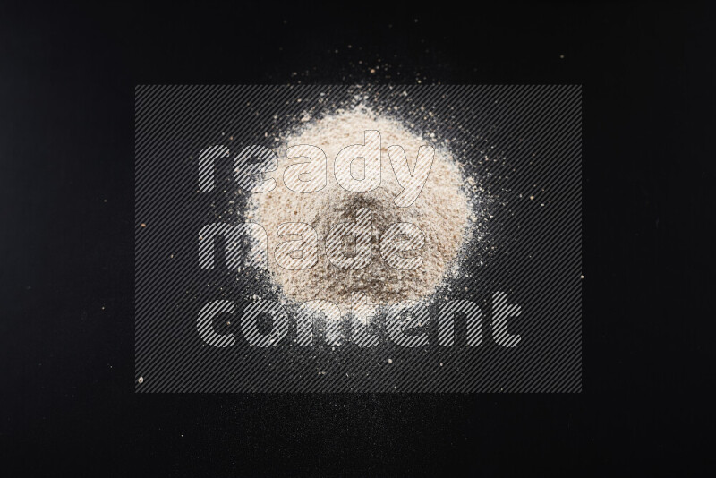 A bunch of onion powder on black background