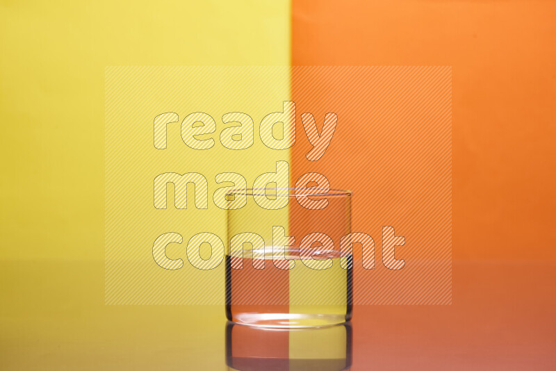 The image features a clear glassware filled with water, set against yellow and orange background