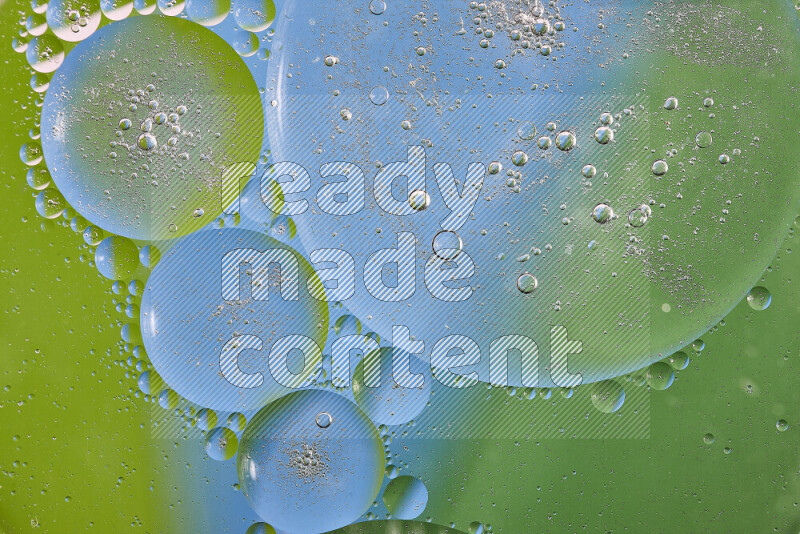 Close-ups of abstract oil bubbles on water surface in shades of green and blue