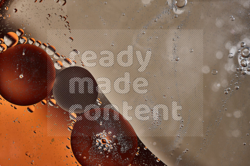 لقطات مقربة لفقاعات من الزيت على سطح الماء باللون البرتقالي والبني