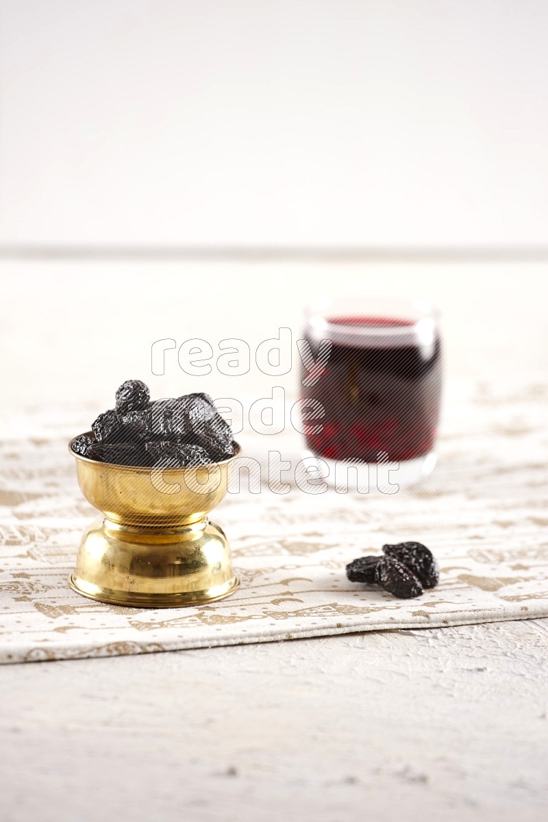Dried fruits in a metal bowl with hibiscus in a light setup