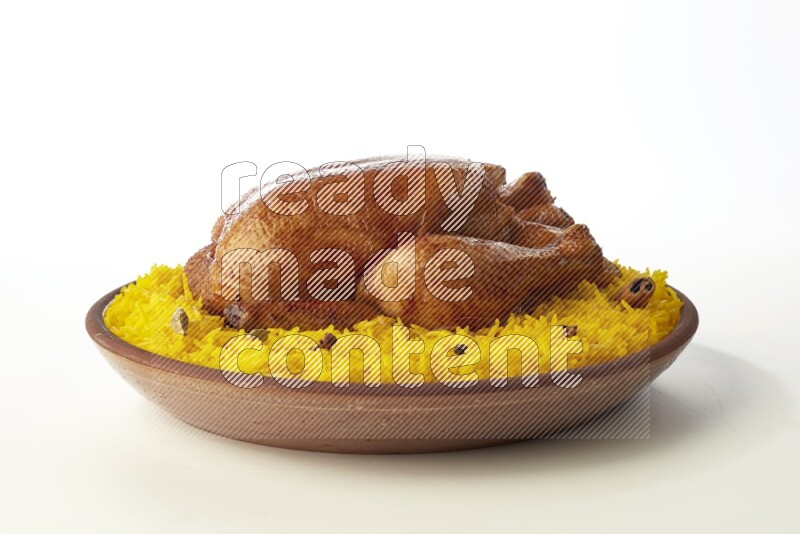 yellow basmati Rice with whole roasted chicken  on a pottery plate  direct  on white background