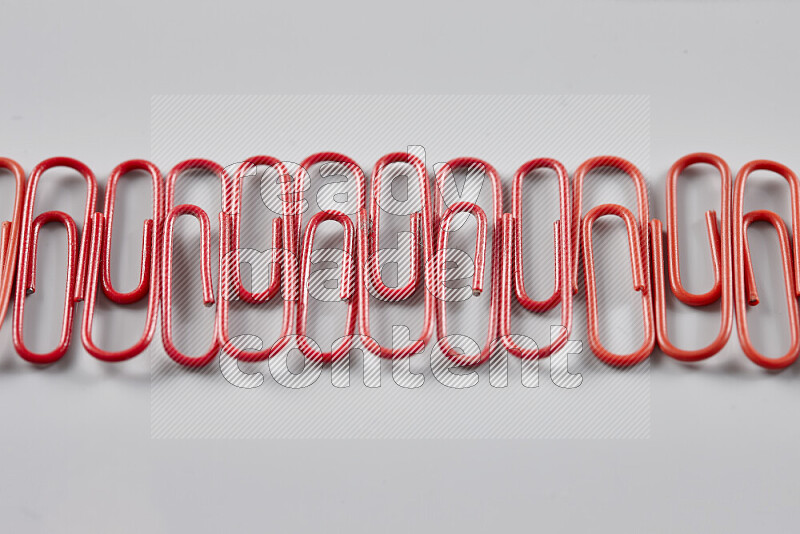 Red paperclips isolated on a grey background