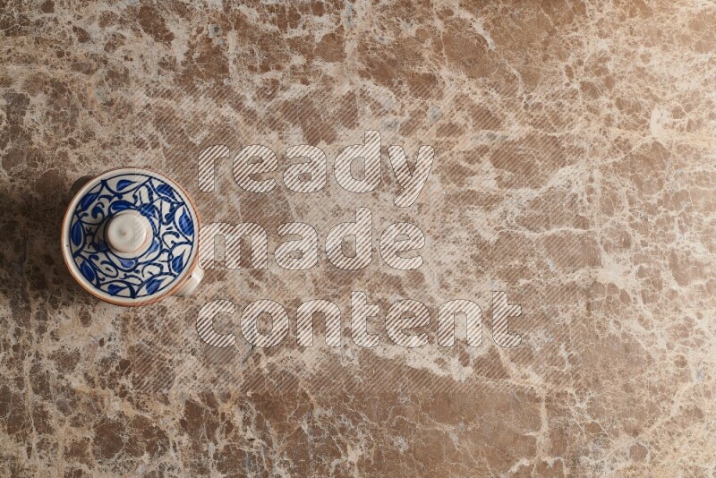 A multicolored pottery pot on beige marble background