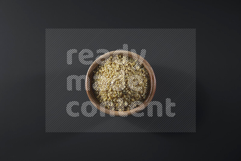 Coarse bulgur in a wooden bowl on grey background