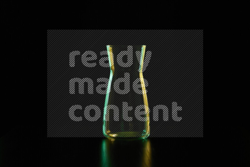 Glassware with rim light in green and yellow against black background