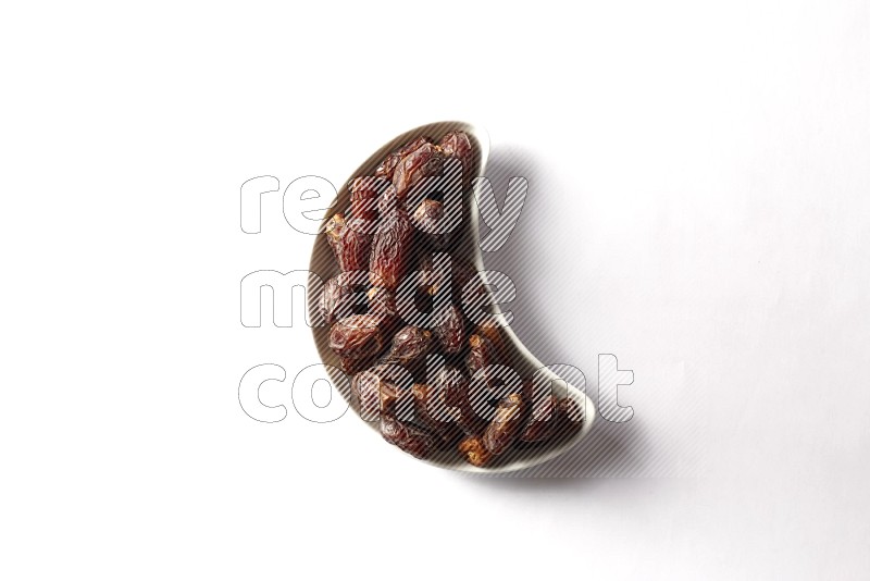 Dates in a crescent pottery plate on white background