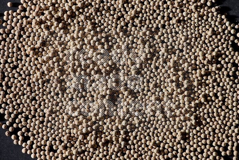 White pepper beads on black flooring