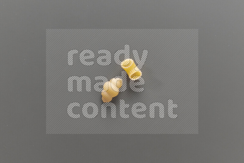 Snails pasta with other types of pasta on grey background