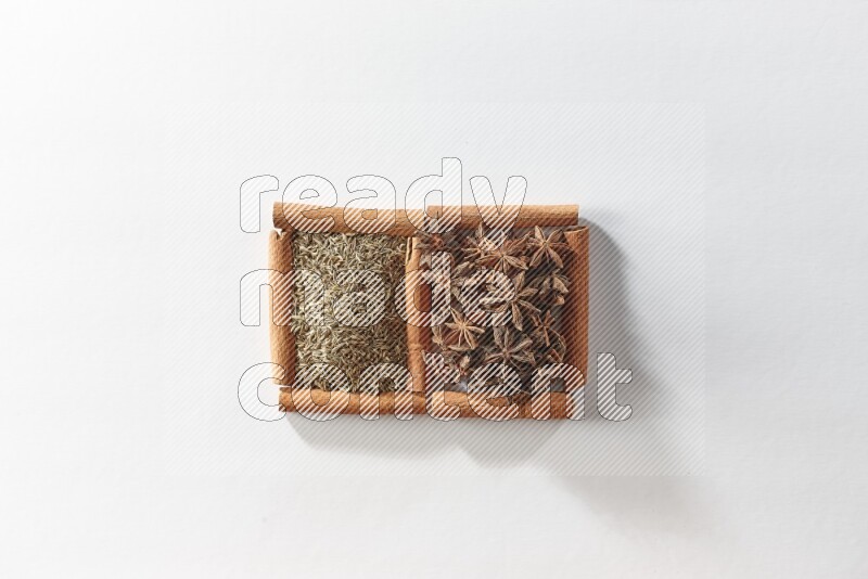 2 squares of cinnamon sticks full of star anise and cumin on white flooring