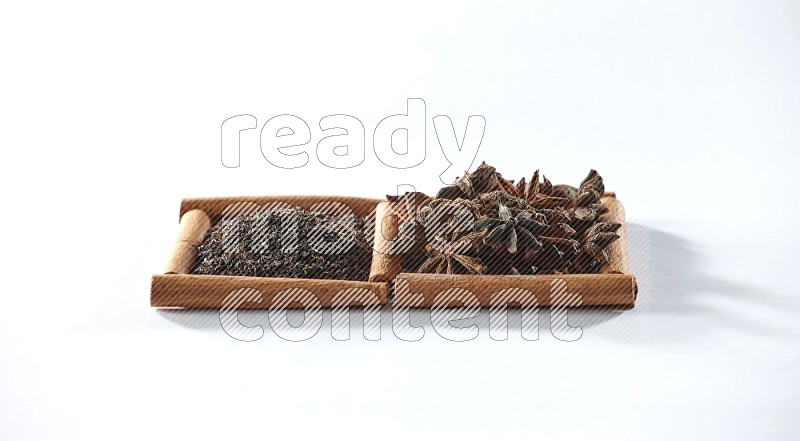 2 squares of cinnamon sticks full of black tea and star anise on white flooring