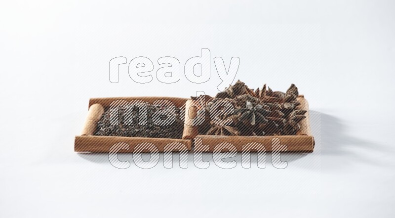 2 squares of cinnamon sticks full of black tea and star anise on white flooring