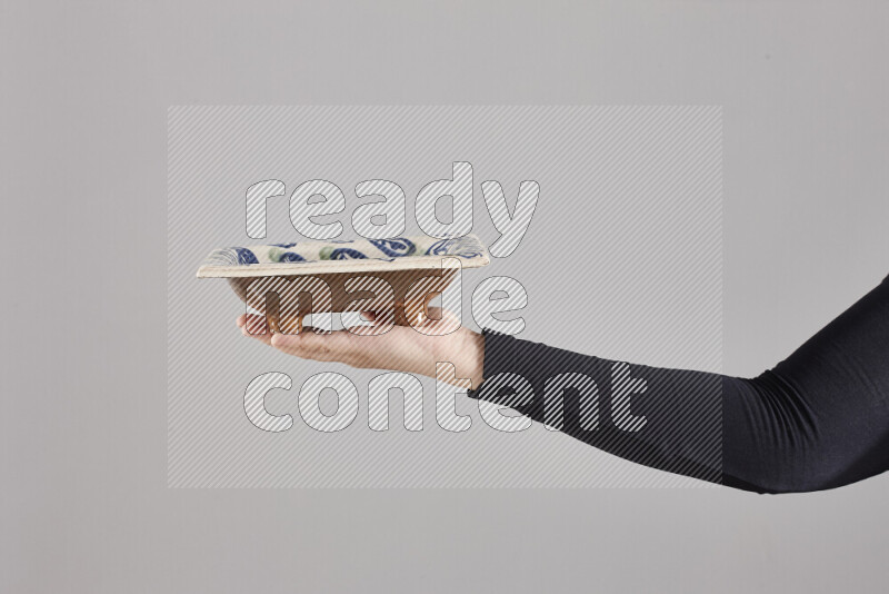 امرأة ترتدي عباءة سوداء تحمل أدوات فخارية مختلفة في أوضاع متعددة