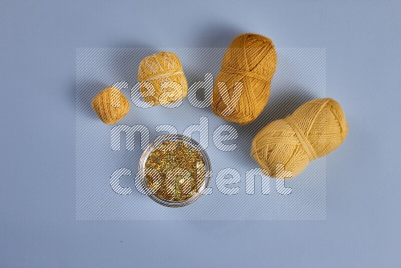 مجموعة من أدوات الخياطة والتفصيل صفراء اللون على خلفية زرقاء