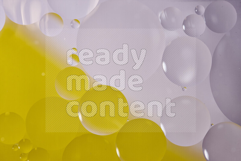 Close-ups of abstract oil bubbles on water surface in shades of white and yellow