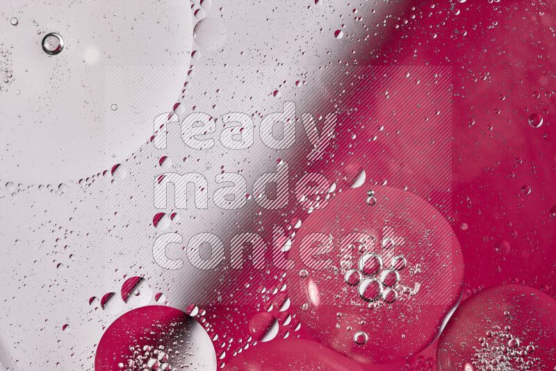 لقطات مقربة لفقاعات من الزيت على سطح الماء باللون الأبيض والوردي