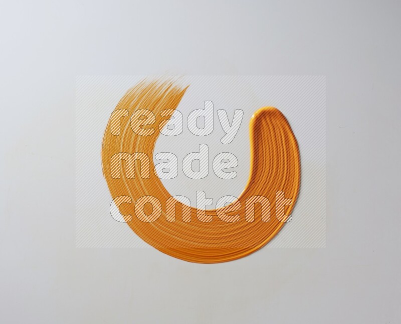 An orange circular painting brush stroke on white background