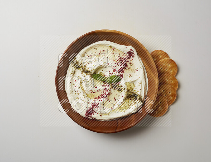Lebnah garnished with  zattar , sumak & mint in a wooden plate on a white background