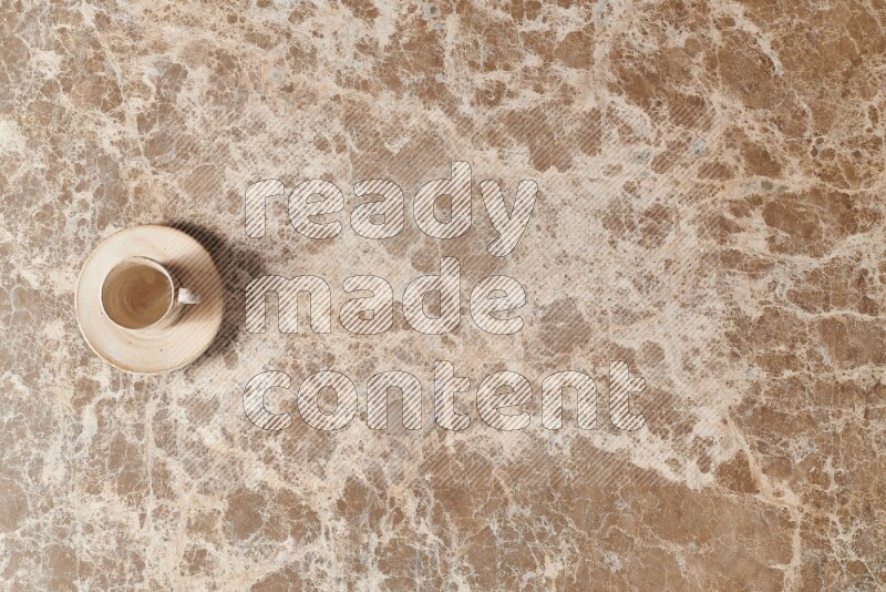 A pottery cup on beige marble background