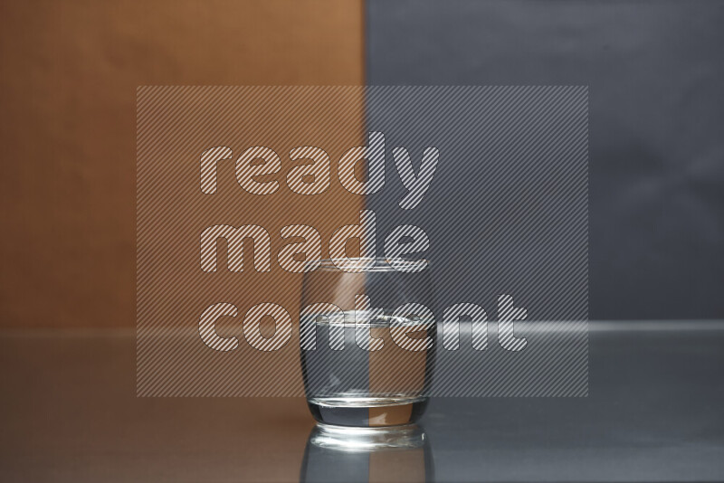 The image features a clear glassware filled with water, set against brown and dark blue background