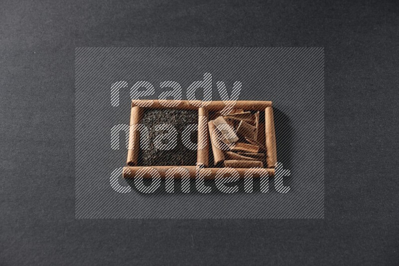 مربعان من أعواد القرفة ممتلئان بالشاي والقرفة علي خلفية سوداء