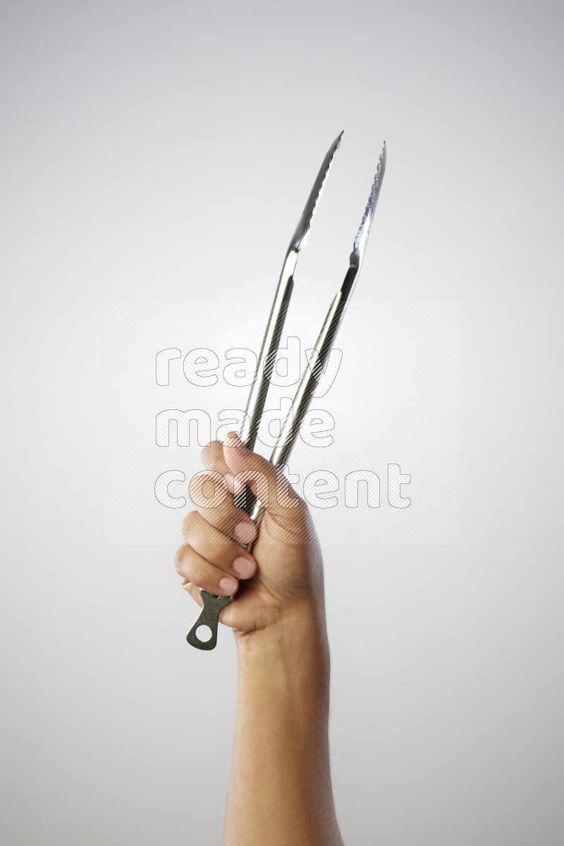 Male Hand Holding Tongs on white background