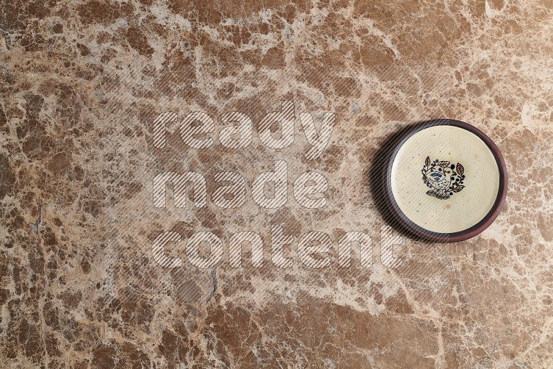 Top View Shot Of A Decorative Pottery Plate On beige Marble Flooring