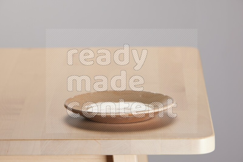 multi-colored pottery Plate on a wooden table edge