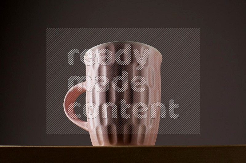 Low angle shot of a pink cup on grey background