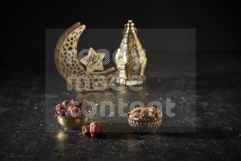 Dates in a metal bowl with almonds beside golden lanterns in a dark setup