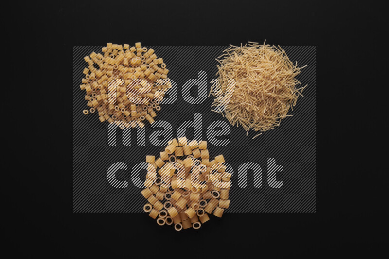 Different pasta types in bunches on black background