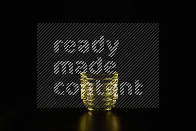 Glassware with rim light in yellow against black background