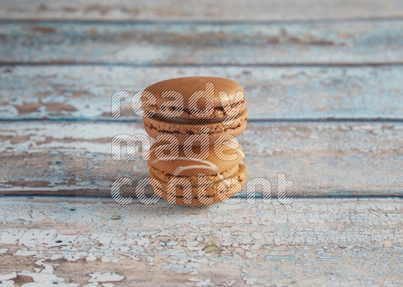 45º Shot of of two assorted Brown Irish Cream, and Brown Coffee macarons on light blue background