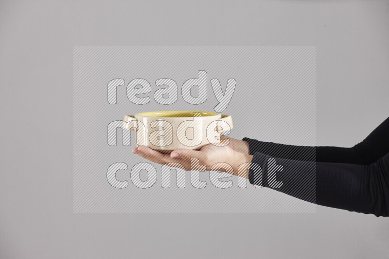 A woman in black abaya holding different pottery essentials in different positions