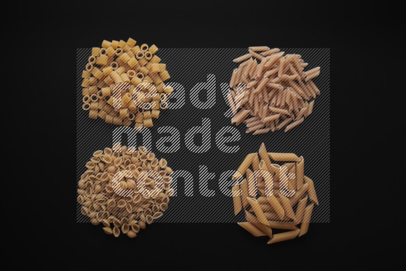 Different pasta types in bunches on black background