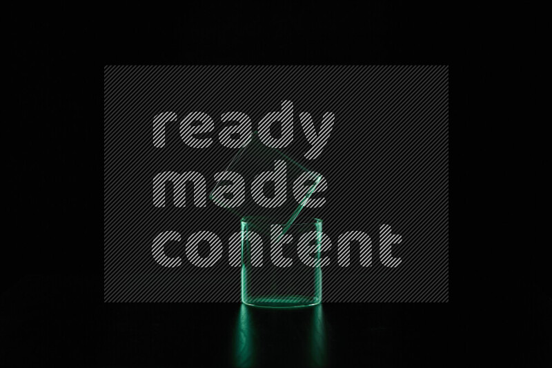 Glassware with rim light in green against black background