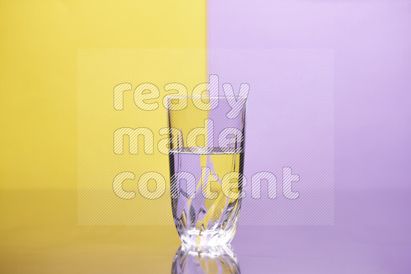 تظهر الصورة أواني زجاجية ممتلئة بالماء موضوعة على خلفية من اللونين الأصفر والأرجواني الفاتح