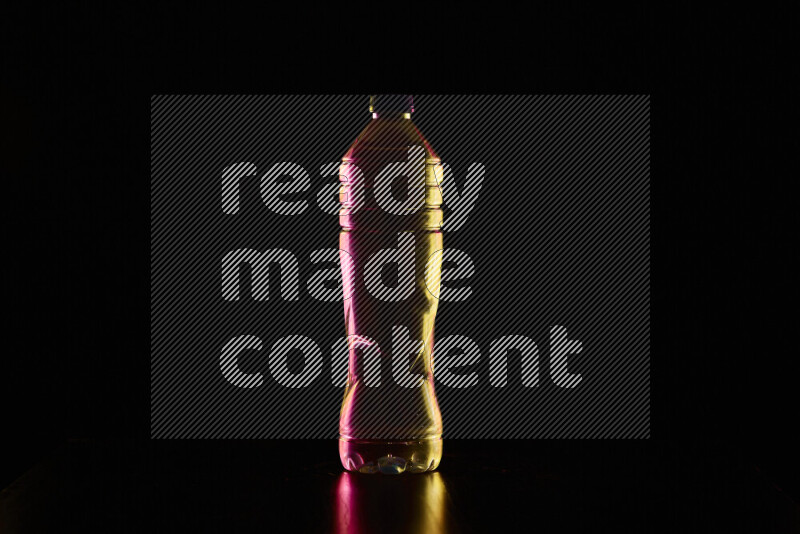 Water bottle with colored rim light against black background