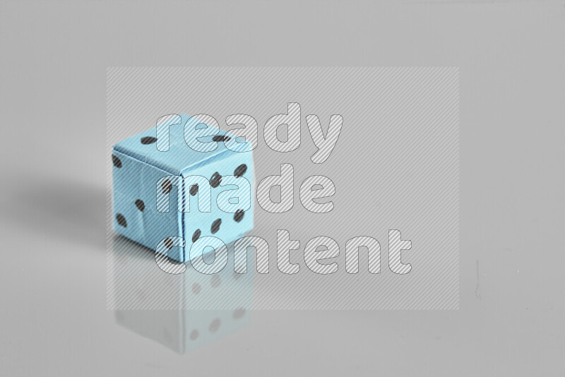 Origami dice on grey background