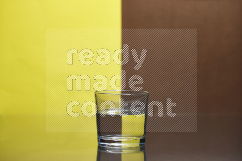 تظهر الصورة أواني زجاجية ممتلئة بالماء موضوعة على خلفية من اللونين الأصفر والبني