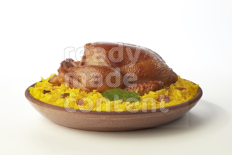 yellow basmati Rice with whole roasted chicken  on a pottery plate  direct  on white background