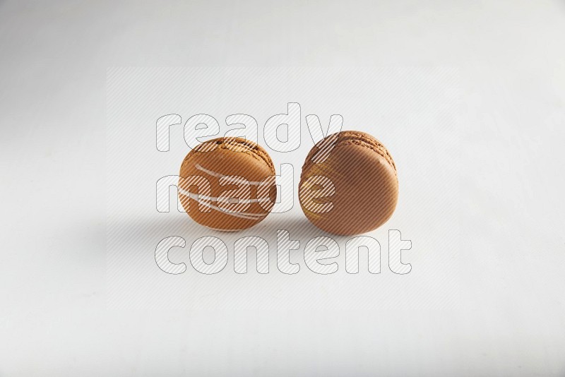 45º Shot of of two assorted Brown Irish Cream, and Brown Coffee macarons  on white background